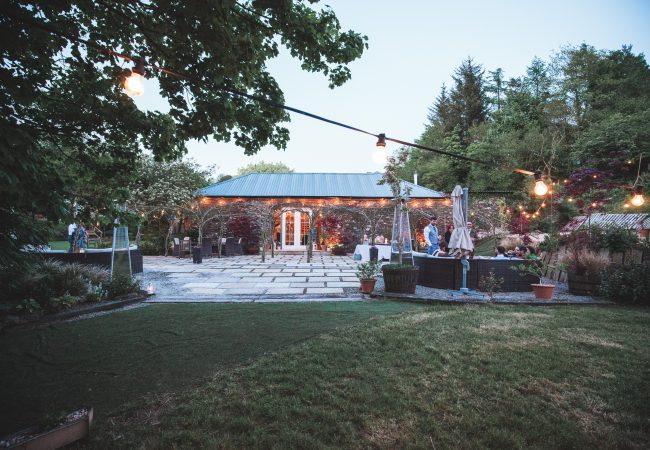 A image of the stone barn at dusk with festoon lighting