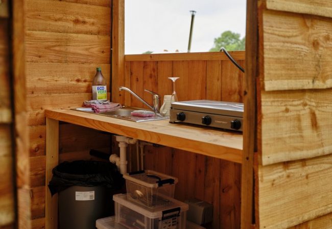 a camping stove and kitchen in a wooden cabin
